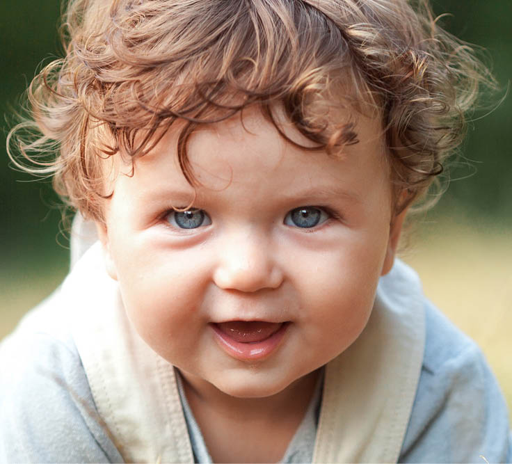 The little baby or year-old child on the grass in sunny summer day. The concept children's months, happy child playing