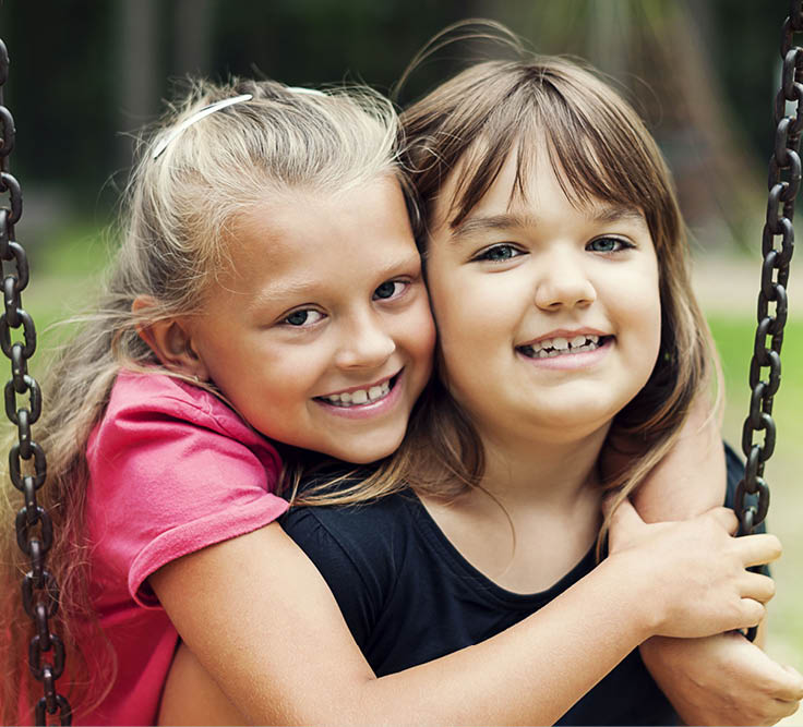 Best friends swinging in a park